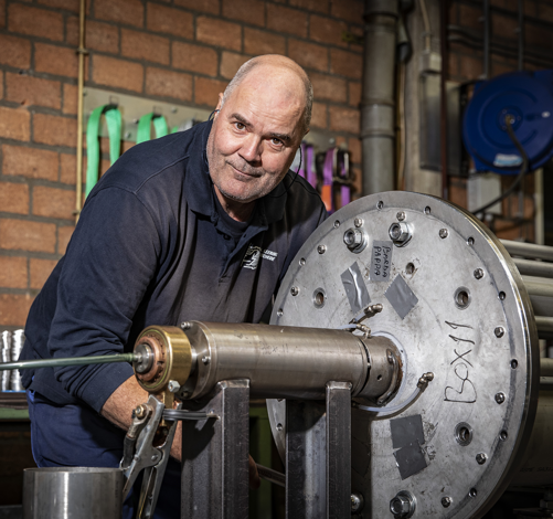 Metaalbewerker kijkt in camera